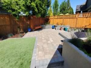 Uplands Drive backyard landscape with artificial turf, pavers and retaining wall