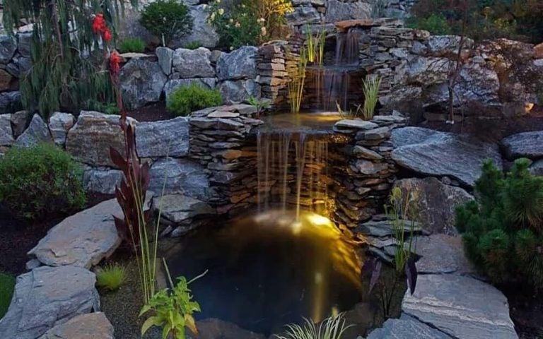 Multi-tier stone waterfall and pond with landscape lighting — Creative By Design Nanaimo